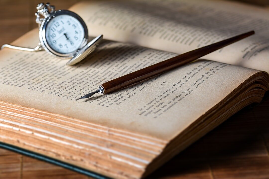 Open old book with a quill pen resting on its pages