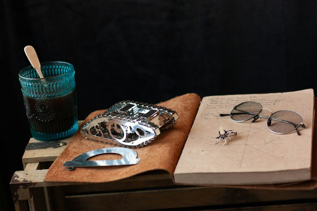 Open leather notebook with handwritten notes and a magnifying glass on a wooden desk